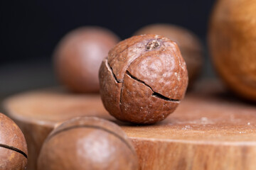 Unpeeled macadamia nuts on a wooden table