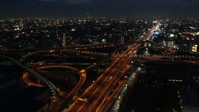 OSAKA, JAPAN - JULY 2023 : Aerial view of high way, road junction and cityscape of downtown. Japanese transportation, street traffic and urban city concept video. Time lapse shot at night.