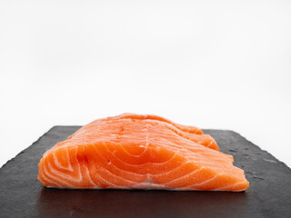 Salmon fish fillet on Slate stone. Red fish fillet close-up on a white background.