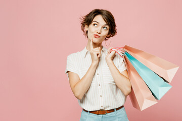 Young minded woman wears casual clothes hold shopping paper package bags prop up chin look aside...