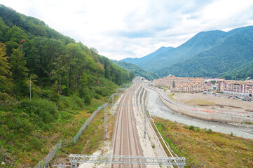 Fototapeta na wymiar Top view of the railway among the mountains and a small town. Rosa Khutor.