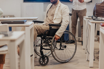 Handicapped man in wheelchair going back to his place at the classroom
