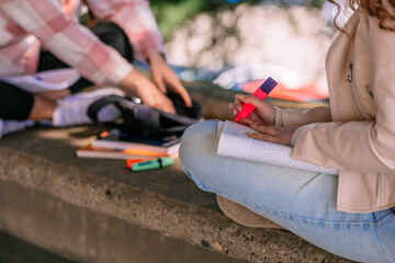 Close up shot of girl underlining most important parts while holding a calculator