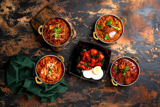Assorted karahi food chicken karahi, mutton korma, beef qorma, lamb kadahi masala, tikka kabab served on food table top view of indian spices