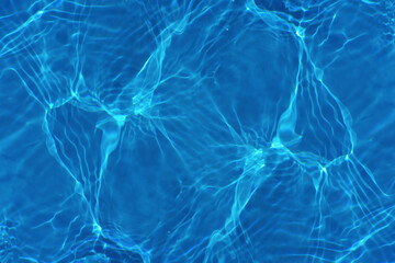 Defocus blurred transparent blue colored clear calm water surface texture with splashes reflection. Trendy abstract nature background. Water waves in sunlight with copy space. Blue watercolor shine