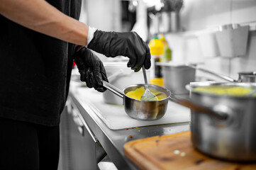 Chef hands cooking cheese sauce in the restaurant kitchen