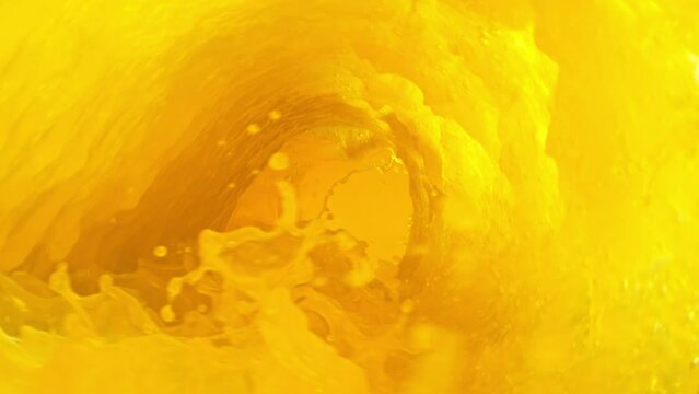 Super slow motion of mixing orange juice in twister shape. Filmed on high speed cinema camera, 1000 fps.