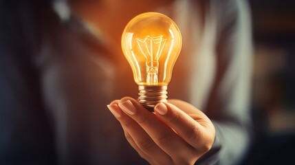 blured Woman in grey blouse holding a light bulb