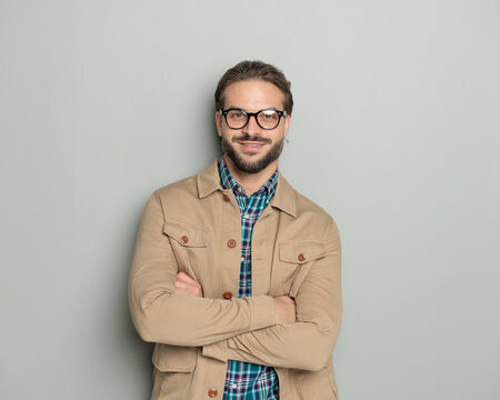 handsome happy man with glasses smiling while crossing arms