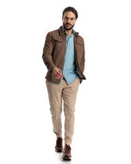 Fototapeta premium casual bearded guy with glasses walking with hand in pocket