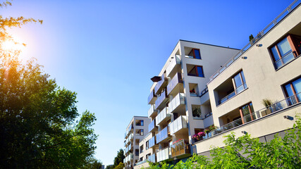 Modern apartment building and green trees. Ecological housing architecture. A modern residential building in the vicinity of trees. Ecology and green living in city, urban environment concept. 