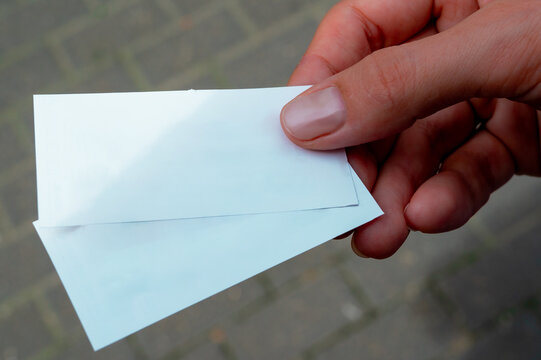 Woman's hand holding tickets. Paper tickets in woman hand. bus, tram, public transport ticket.
Mock up, copy space.