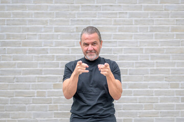 Portrait of an attractive friendly man pointing to the camera