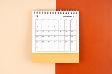 The Directly above view of December 2023 desk calendar on orange color background.