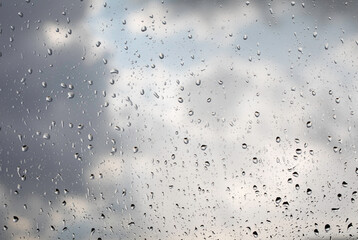 Water drops on the window pane, glass. Defocused lights of the city. Bokeh - abstract background. Colorful and vivid.