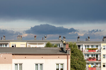 Dramatic colorful sky, before storm and during sunset. Huge clouds formations above residential blocks