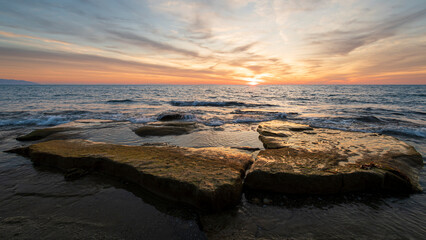 Waves on the rocks at the seaside at the sunset - 648910984