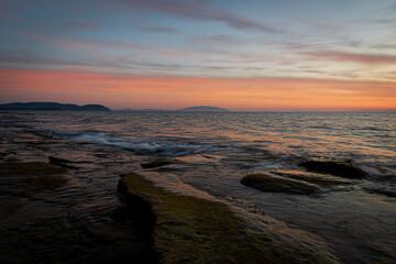 View of Elba island from Tuscany coast with flat rocks in the foreground - 648910992