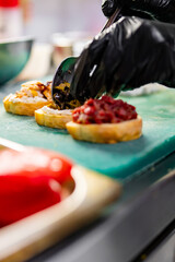 chef hand cooking tapas on restaurant kitchen