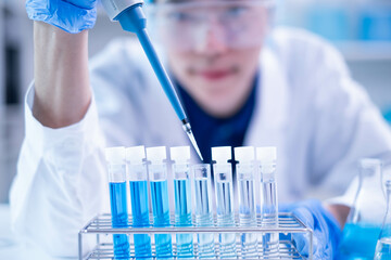 Professional scientist chemist technician analysis research experiment virus blue liquid pipette glass test tube equipment in hospital laboratory, woman doctor white lab coat medical research develop