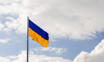 Ukrainian flag blowing on the wind with free sky background space