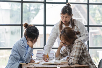 College students using laptop while sitting at table. Group study for school assignment.