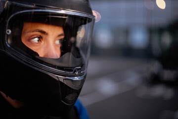 close-up view of a female motorcyclist, woman in a helmet in the evening.