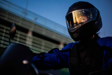 Female motorcyclist in a helmet and motorcycle jacket close-up. A woman's motorcycle life.