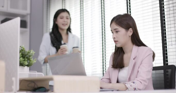 Two Asian business women are sitting and working in the office. Teamwork will make the team successful. Working with data technology is good business planning.