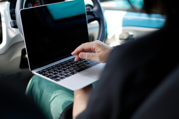 車の中でパソコンを使う女性