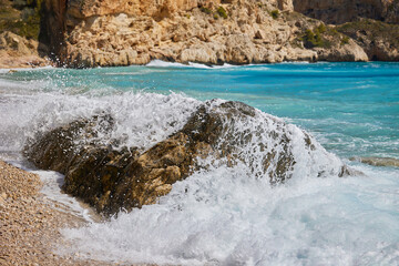 Waves waves crashing against rocks on the shores of the Mediterranean Sea during the day. Cala del...