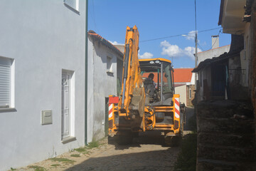 tractor passing through a very narrow street in a village