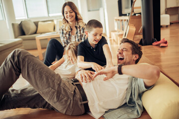 Young Caucasian family playing in the living room at home