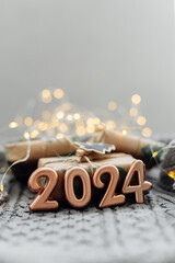 Christmas and New Year Greeting Card. Number 2024 on knitted background. Holiday lights bokeh background. Happy New Year 2024 Concept. - 648955595