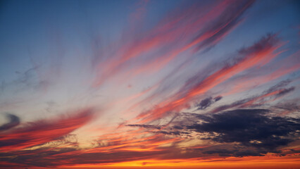 As dawn breaks, the sky transitions from darkness to a bright blue, signaling the arrival of a new day