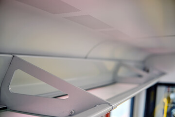 A shelf for bags from above under the ceiling. A place for luggage above the seats on the train.