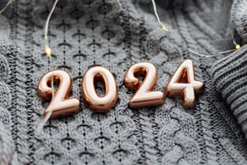 Christmas and New Year Postcard. Number 2024 on knitted gray background. Happy New Year 2024