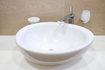 Chrome faucet with white ceramic sink in the bathroom