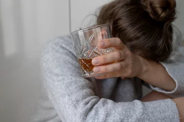 Zelfklevend Fotobehang alcoholism, alcohol addiction . drunk woman or female alcoholic drinking whiskey at home. Loneliness and stress. Female alcoholism.  © olga
