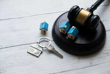 Concept of real estate auction, legal system and property division after divorce. Gavel and house key on a wooden background.