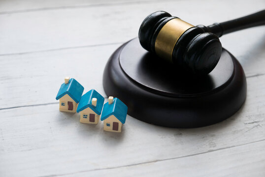 Concept of real estate auction, legal system and property division after divorce. Gavel and house key on a wooden background.