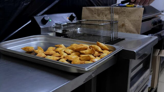 The process of frying chebureks in boiling oil. Pasties with meat fried in sunflower oil, deep-fried. Pie or cheburek is deep-fried.