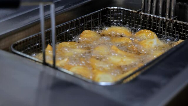 The process of frying chebureks in boiling oil. Pasties with meat fried in sunflower oil, deep-fried. Pie or cheburek is deep-fried.