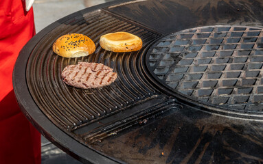 The hamburger is cooked on a hot grill.