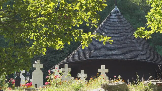 The One Wood Monastery surrounded by cemetery white crosses, Valcea, Romania