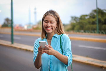 Joyful Latin Woman Texting and Smiling in the City