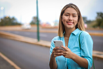 Happy Hispanic Girl Enjoying Phone Time Outdoors