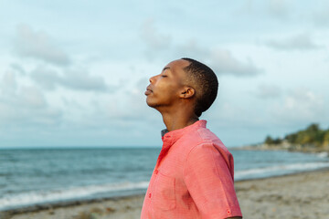 Casual man with black skin breathing fresh air on the beach