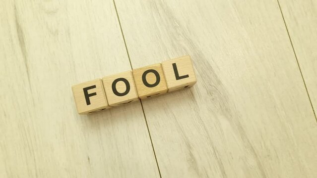 Fool word from wooden blocks. April Fools Day concept