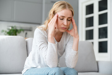 Stressed, tired woman with closed eyes feeling strong headache pain